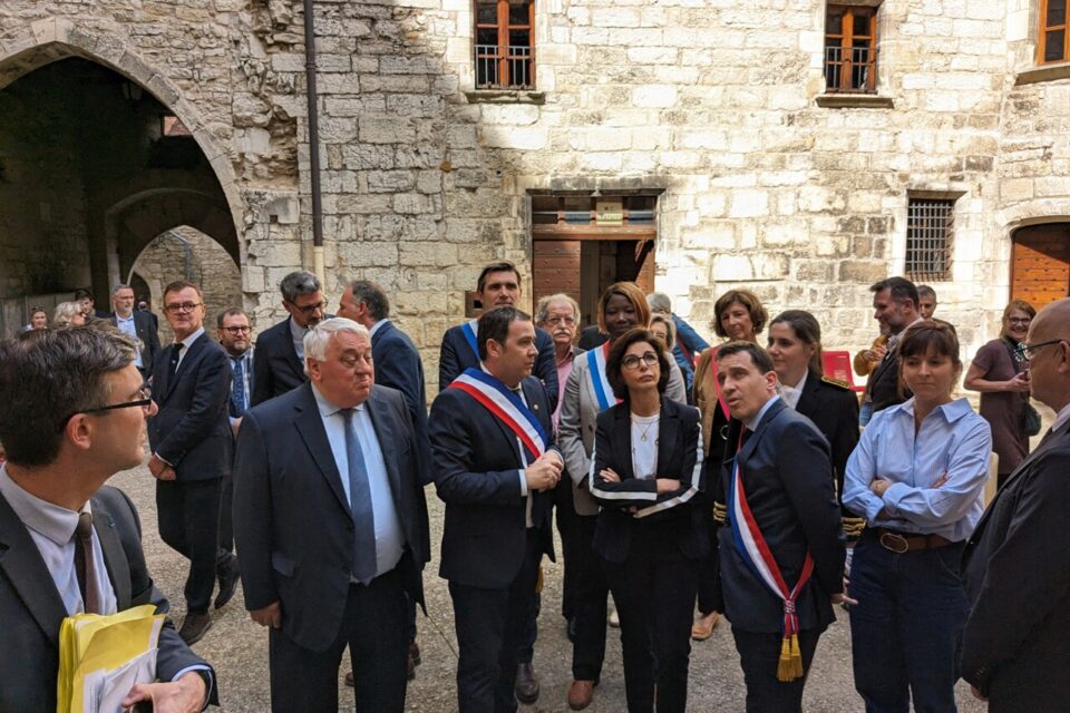 Dans la cour du Palais de la Raymondie, la ministre écoute les observations du sénateur Raphaël Daubet et du maire, concernant les travaux en projet pour une mise aux normes...